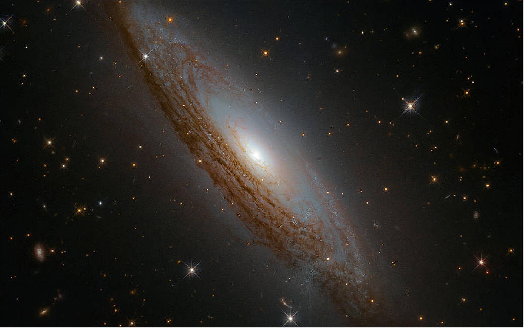 Figure 1: This galaxy has something known as an active galactic nucleus. While this phrase sounds complex, this simply means that astronomers measure a lot of radiation at all wavelengths coming from the center of the galaxy. This radiation is generated by material falling inward into the very central region of ESO 021-G004, and meeting the behemoth lurking there — a supermassive black hole. As material falls toward this black hole it is dragged into orbit as part of an accretion disk; it becomes superheated as it swirls around and around, emitting characteristic high-energy radiation until it is eventually devoured. The data comprising this image were gathered by the Wide Field Camera 3 aboard the NASA/ESA Hubble Space Telescope (image credit: ESA/Hubble & NASA, D. Rosario et al.)