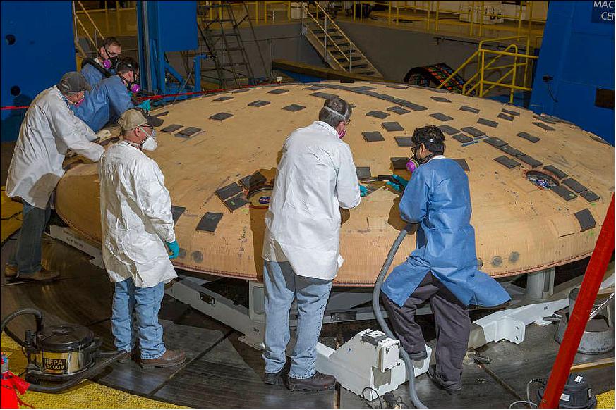 Figure 15: Engineers from NASA/ARC and NASA/MSFC remove segments of a heat-resistant material called Avcoat from the surface of the Orion heat shield, the protective shell designed to help the next-generation crew module and its future occupants withstand the heat of atmospheric reentry. The work is being conducted in the seven-axis milling machine facility at Marshall (image credit: NASA/MSFC)