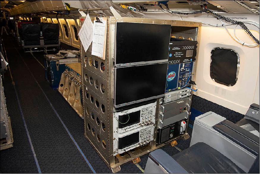 Figure 13: The HALO system electronics and diagnostic tools are integrated onto the DC-8 airborne science laboratory at NASA Armstrong Flight Research Center in Edwards, California. The lidar system control electronics are on the right hand side of the rack. The large monitors on the left are used to display real-time images of water vapor and aerosol profiles, which are used by the science team to guide in-flight decisions and navigation. The compact HALO instrument head can be seen directly behind the electronics rack (image credit: NASA/Lauren Hughes)