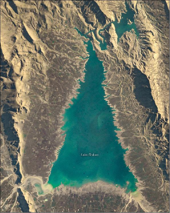 Figure 1: This image was taken on December 3, 2018, by astronaut Alexander Gerst. Lake Dukan is separated into two parts by a winding gorge. The larger portion looks like the body of an evergreen conifer, while the smaller lake is reminiscent of a tree topper. The 'ornaments' on the tree (the dark circles) are artifacts from the astronaut's camera lens (image credit: NASA Earth Observatory, ISS photography by Alexander Gerst, European Space Agency/NASA. Story by Kasha Patel)