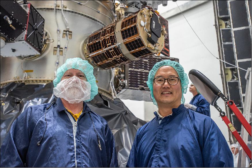 Figure 7: Photo of Ronald Phelps (left) and Daniel Sakoda (lead engineer of NPSat-1) with the NPSat-1 spacecraft above their heads in the integration hall of SpaceX (image credit: SpaceX)