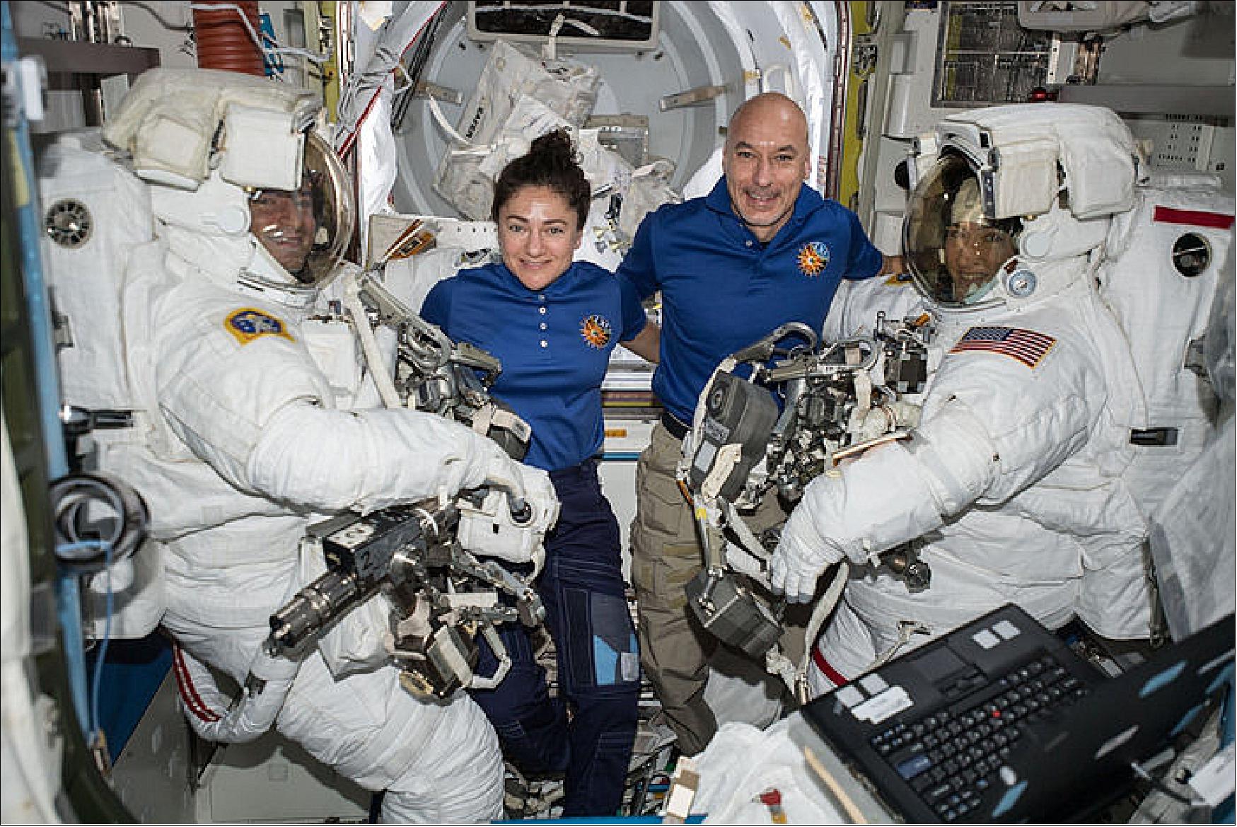 Figure 35: Astronauts assist spacewalkers in the Quest airlock. NASA astronauts Andrew Morgan (left) and Christina Koch (right) are suited up in U.S. spacesuits before beginning a seven hour and one minute spacewalk to upgrade the station's large nickel-hydrogen batteries with newer, more powerful lithium-ion batteries. In the center, NASA Flight Engineer Jessica Meir and Commander Luca Parmitano of ESA assist the spacewalking duo (image credit: NASA)