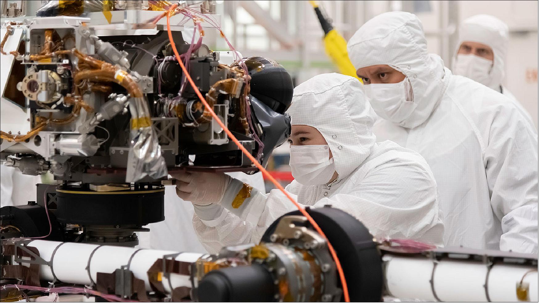Figure 4: Engineers at JPL install a sensor-filled turret on the end of the rover's 2.1 m long robotic arm. The image was taken on July 11, 2019. The rover's turret includes HD cameras, SHERLOC (Scanning Habitable Environments with Raman & Luminescence for Organics & Chemicals) science instrument, PIXL (Planetary Instrument for X-ray Lithochemistry), and a percussive drill and coring mechanism (image credit: NASA/JPL-Caltech)