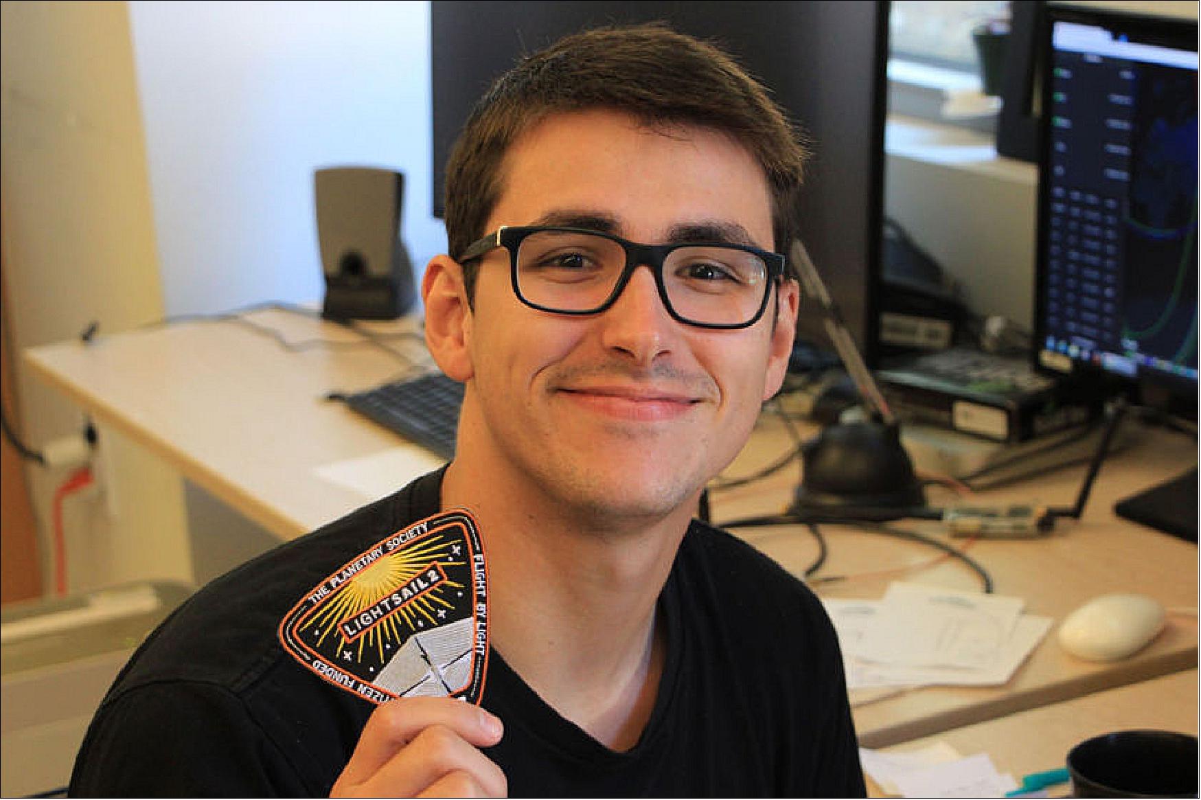 Figure 12: Cal Poly physics undergraduate Michael Fernandez holds a LightSail-2 patch at the Cal Poly CubeSat Laboratory (image credit: Bruce Betts, The Planetary Society)